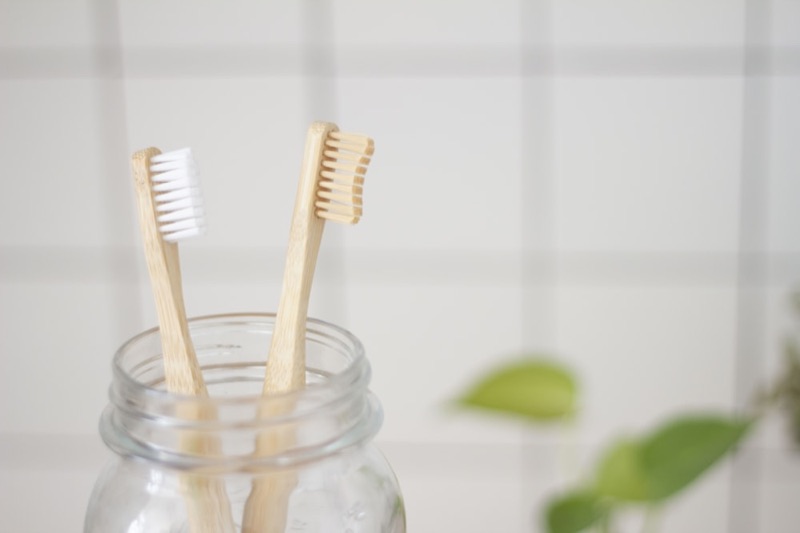 Bamboo dental kit with kraft sleeve on a neutral background